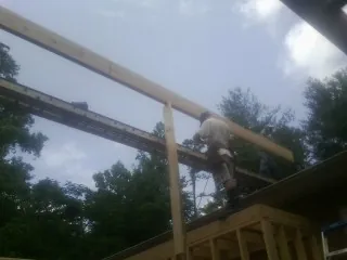 Carpenter setting a ridge beam over a new addition frame — Ice Dam Removal by Roofing Brothers in Oak Creek