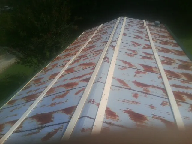 Rusted metal roof panels with new wood purlins before replacement — Storm Damage Roof Repair in Oak Creek by Roofing Brothers