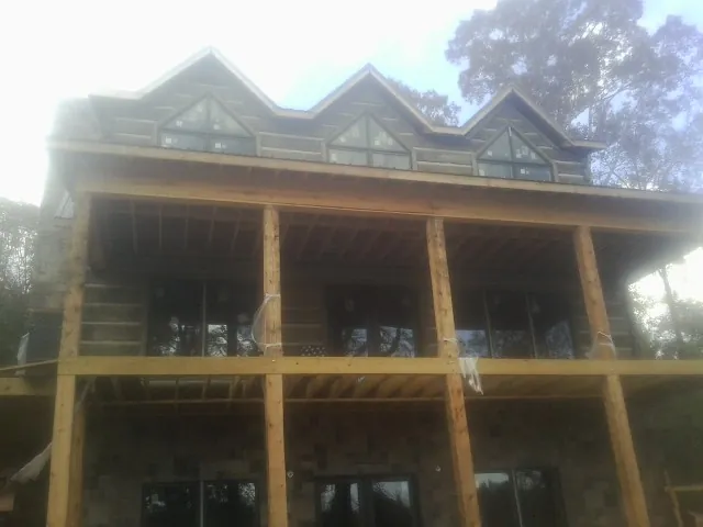 Dormers and porch framing on a large log home under construction — Roof Coating work by our crew in Oak Creek