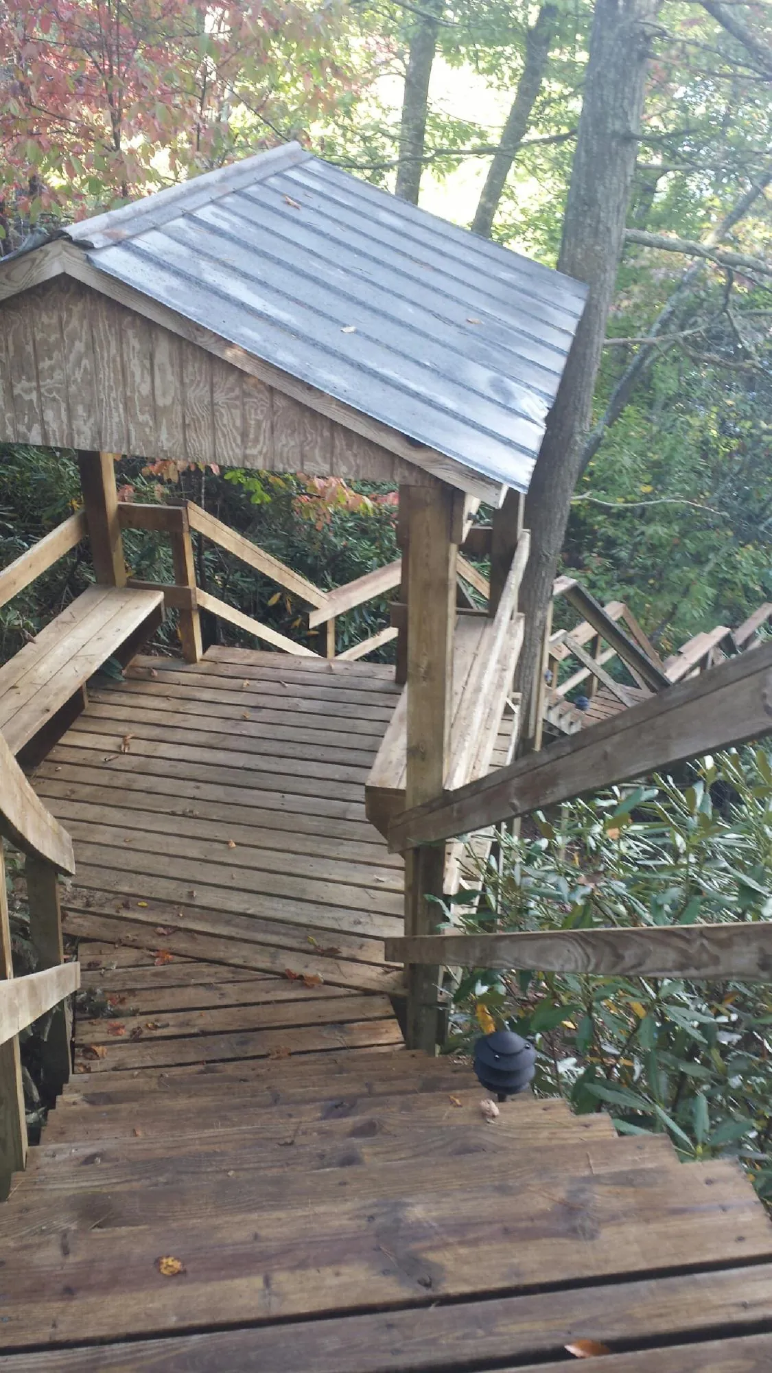 Metal roofed shelter over wooden steps on a wooded walkway — Skylight Repair & Installation work by our crew in Oak Creek