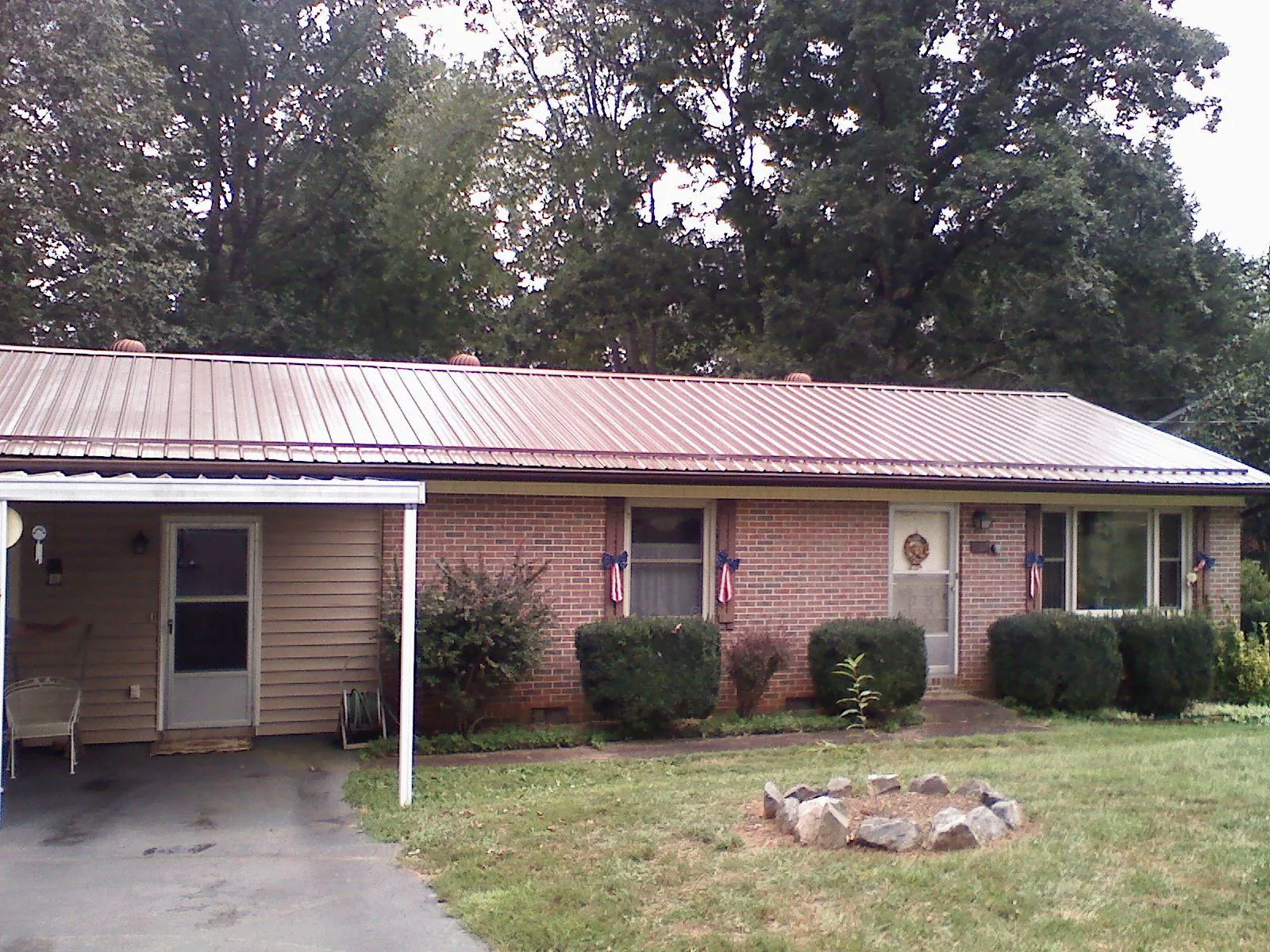 Bronze metal roof and carport on a brick ranch home — Roof Repair work by our crew in Oak Creek