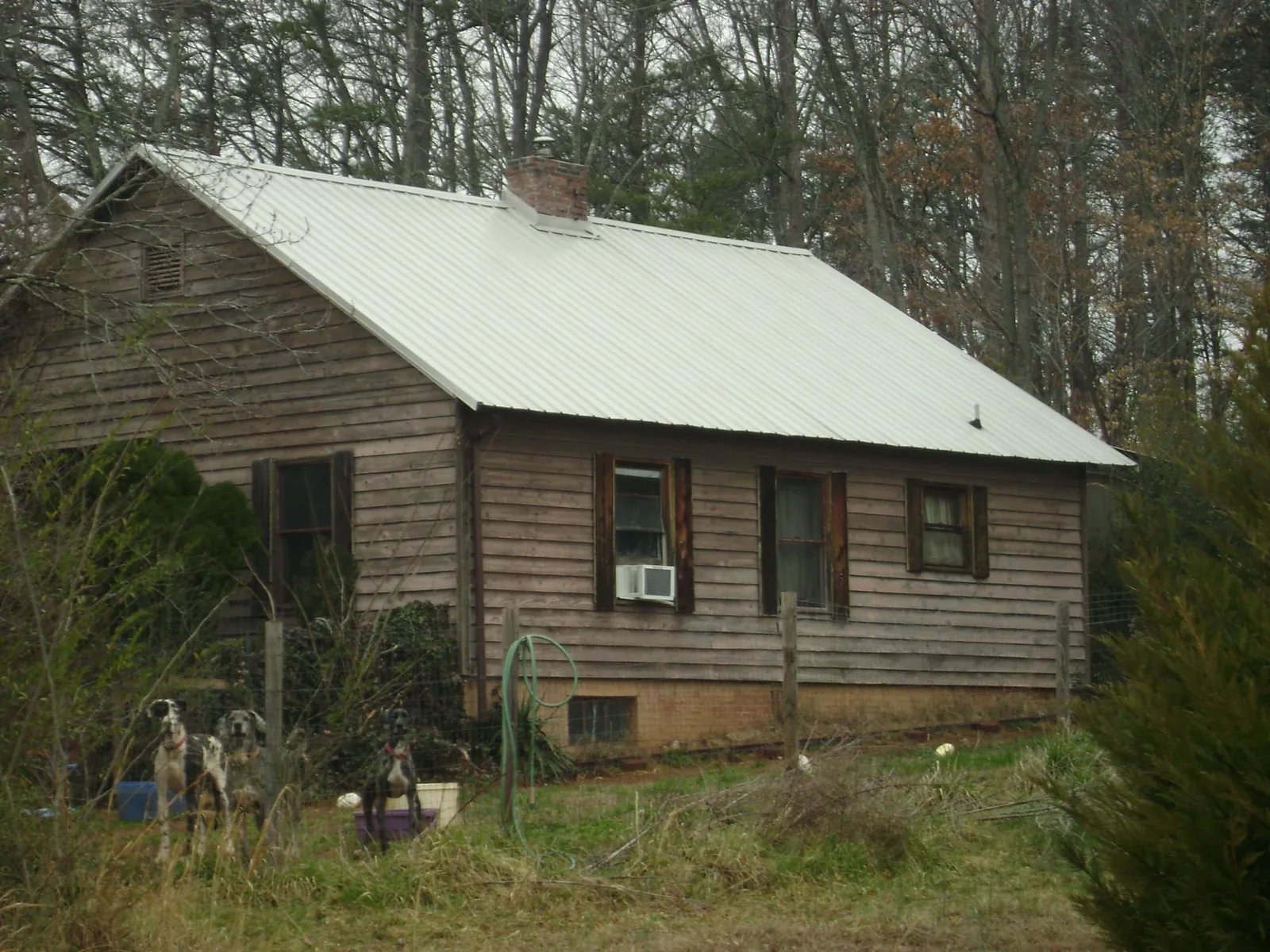 White metal roof on an old wood sided farmhouse, from a Asphalt Shingle Roof Repair job in Oak Creek